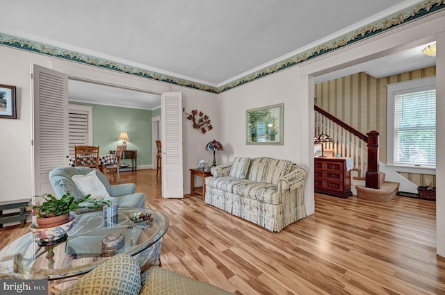 living area with stairway, baseboards, light wood finished floors, and ornamental molding