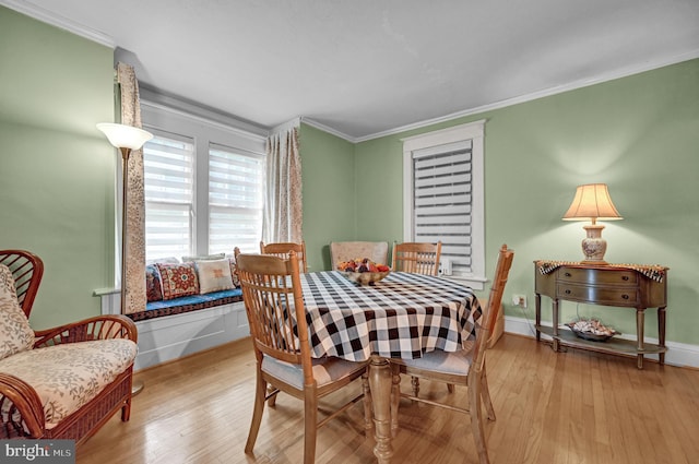 dining room with wood finished floors, baseboards, and ornamental molding