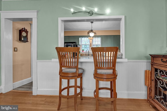 dining space featuring a wainscoted wall and wood finished floors