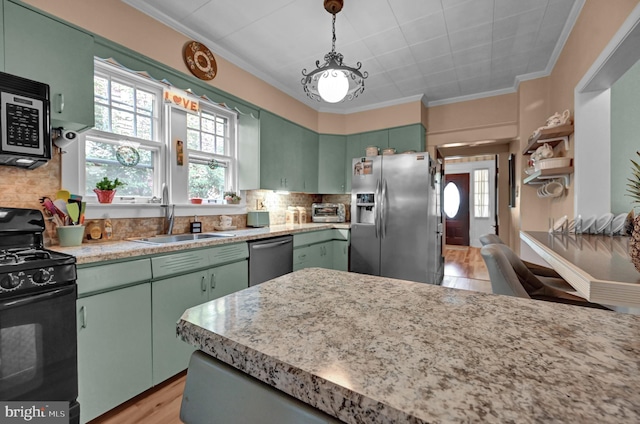 kitchen featuring a sink, backsplash, appliances with stainless steel finishes, and green cabinets