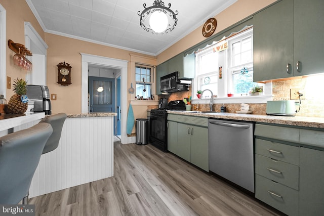 kitchen with a sink, black gas range, light wood-style floors, stainless steel dishwasher, and crown molding