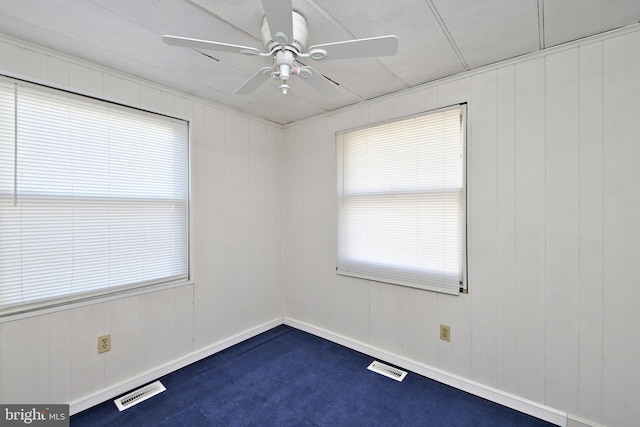 spare room featuring baseboards, visible vents, and ceiling fan