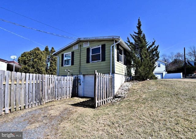 view of side of property with an attached garage and fence