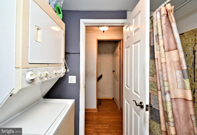 laundry room with laundry area, stacked washer and clothes dryer, and wood finished floors