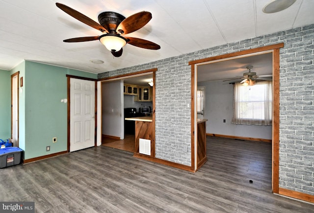 unfurnished living room featuring wood finished floors, a ceiling fan, visible vents, and baseboards