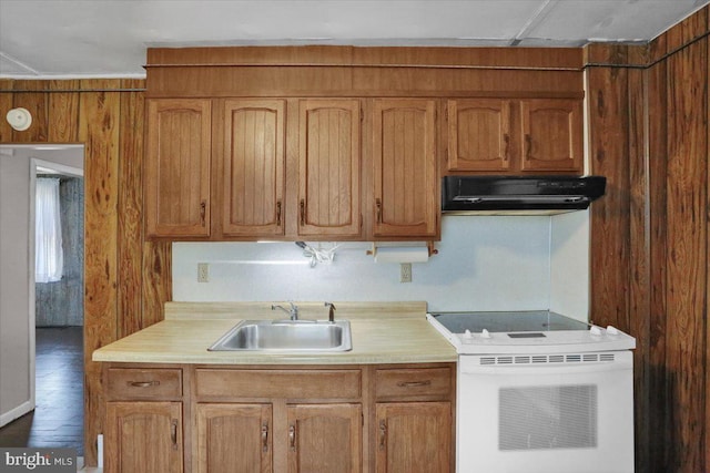 kitchen featuring a sink, light countertops, under cabinet range hood, and white range with electric cooktop