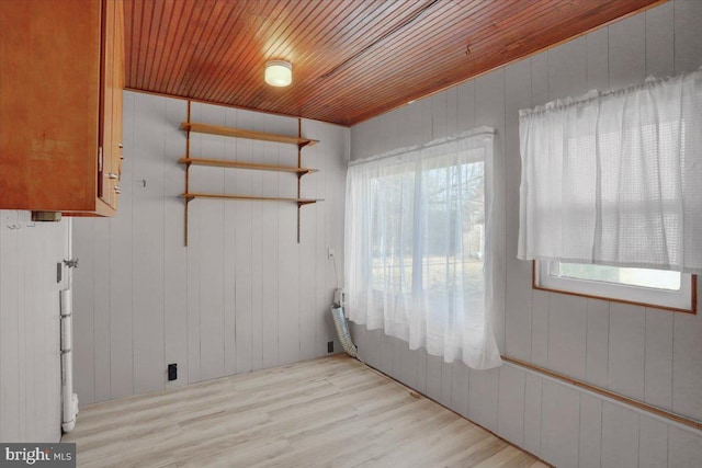 unfurnished room with wood ceiling and light wood-type flooring