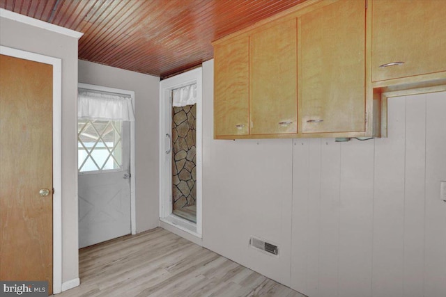 foyer entrance with visible vents, light wood-style floors, and wooden ceiling