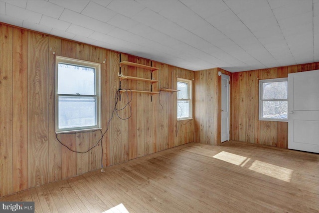 unfurnished room featuring wooden walls and hardwood / wood-style floors