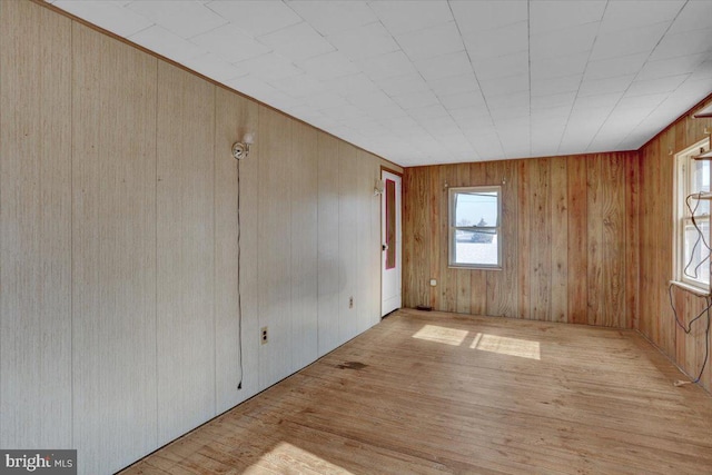 unfurnished room featuring wood finished floors and wood walls