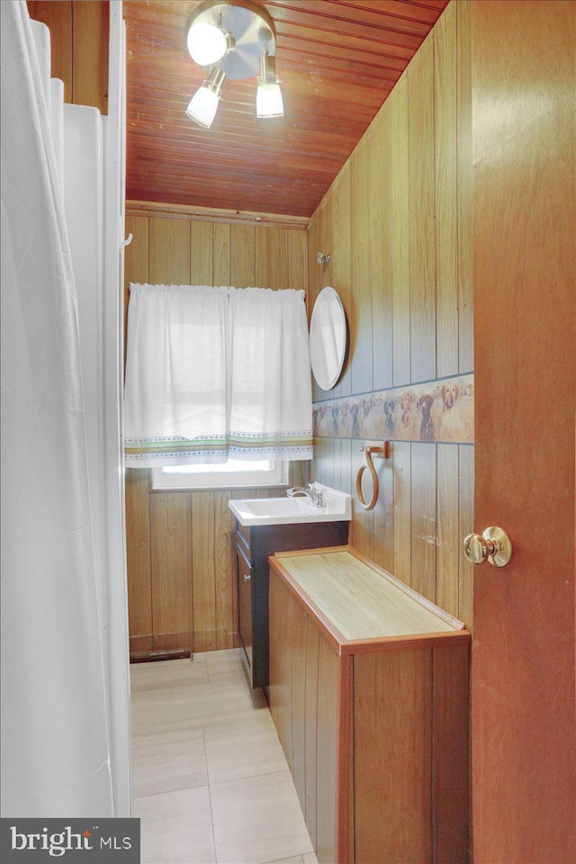 washroom featuring light tile patterned floors, wood ceiling, and wood walls