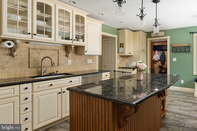 kitchen featuring cream cabinetry, a sink, glass insert cabinets, baseboards, and dishwasher