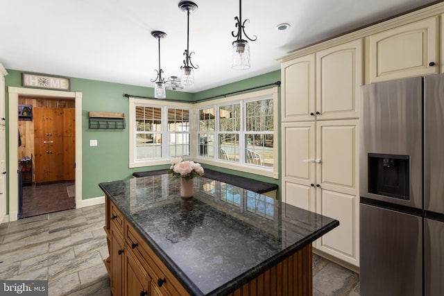 kitchen featuring a center island, baseboards, pendant lighting, cream cabinets, and stainless steel refrigerator with ice dispenser