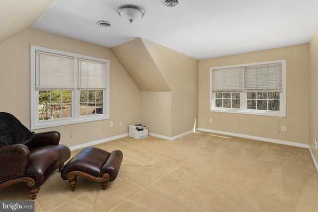 living area featuring visible vents, light carpet, plenty of natural light, and baseboards