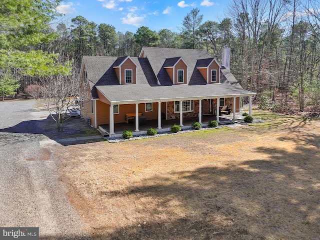 view of front of property featuring covered porch, driveway, and a shingled roof