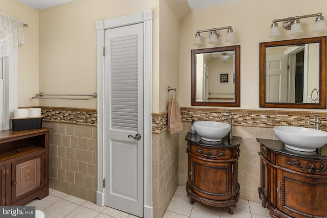 bathroom with tile walls, two vanities, and a sink