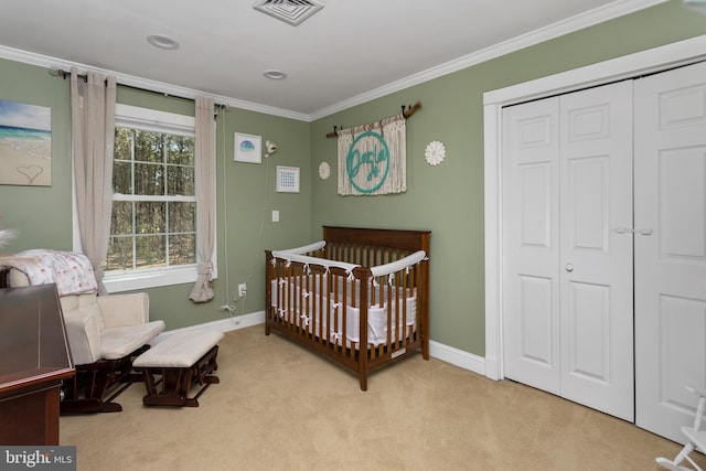 carpeted bedroom featuring visible vents, a crib, a closet, crown molding, and baseboards