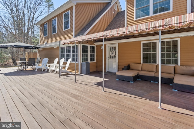 wooden terrace with outdoor dining space and an outdoor hangout area