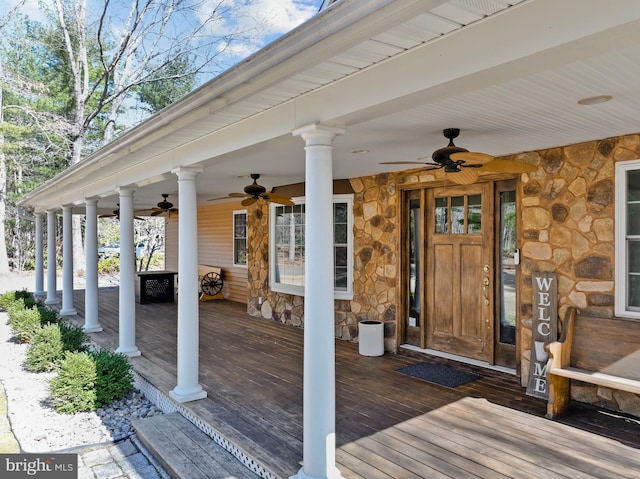 property entrance with stone siding, covered porch, and a ceiling fan