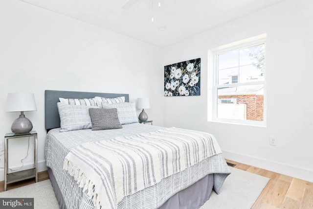 bedroom with baseboards, wood finished floors, and a ceiling fan