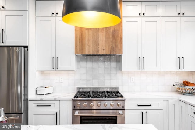 kitchen with white cabinets, backsplash, and stainless steel appliances