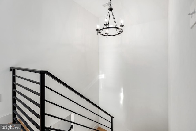 staircase featuring visible vents and an inviting chandelier