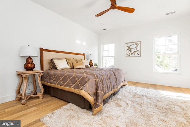 bedroom featuring wood finished floors, visible vents, and baseboards