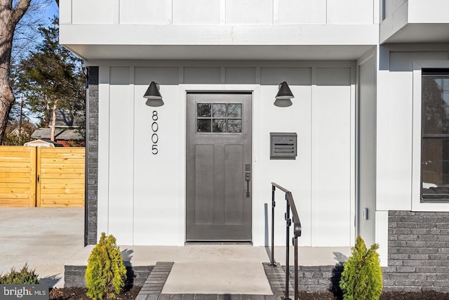 doorway to property featuring fence