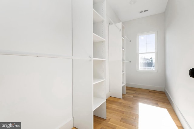 spacious closet with light wood-style floors and visible vents