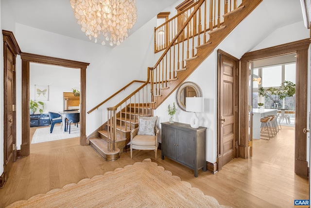 staircase featuring an inviting chandelier and wood finished floors