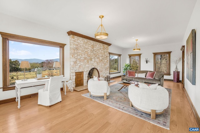 living area with a mountain view, baseboards, and light wood-type flooring