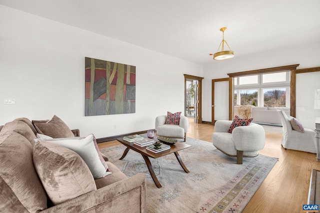 living area featuring baseboards and light wood-style floors