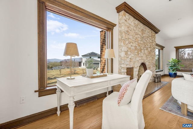 dining area featuring baseboards, wood finished floors, and a fireplace