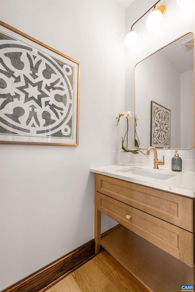 bathroom featuring vanity, baseboards, and wood finished floors