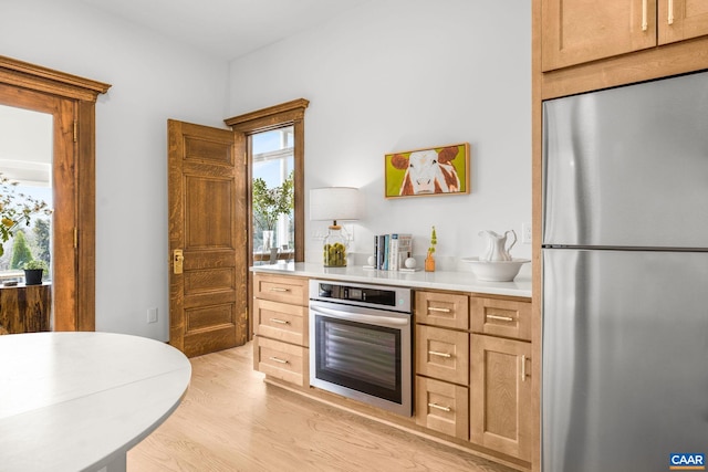 kitchen featuring light countertops, light wood-style flooring, and stainless steel appliances