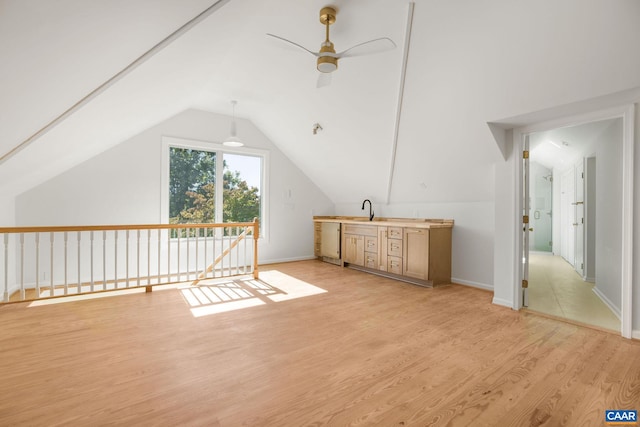 bonus room with a ceiling fan, baseboards, light wood-style flooring, a sink, and vaulted ceiling