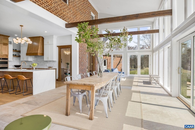 dining area with recessed lighting, beam ceiling, high vaulted ceiling, and an inviting chandelier