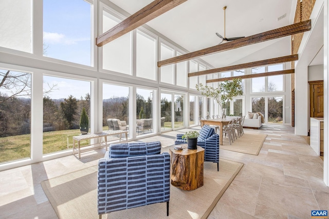 sunroom featuring a ceiling fan, vaulted ceiling with beams, and a healthy amount of sunlight