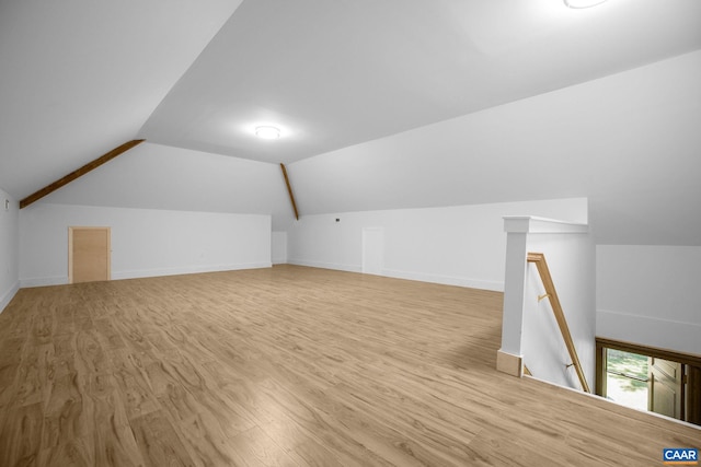 bonus room featuring vaulted ceiling, light wood-style flooring, and baseboards