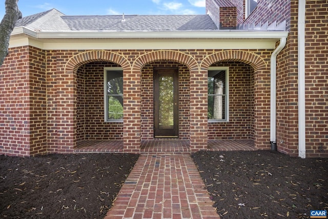 entrance to property featuring brick siding