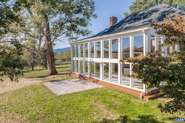 view of yard with a mountain view and a sunroom