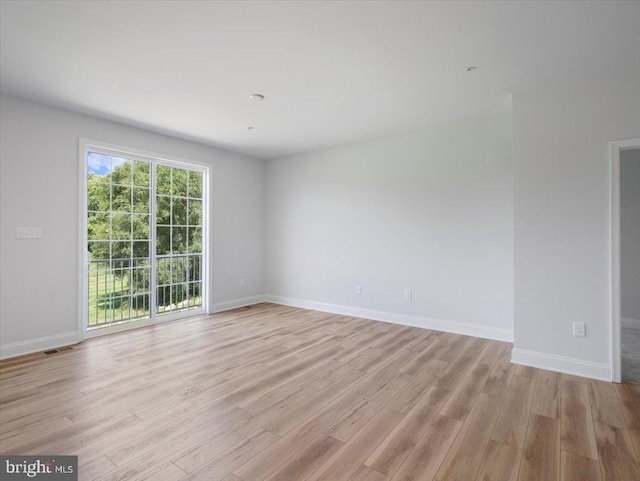 spare room featuring visible vents, baseboards, and light wood-style floors