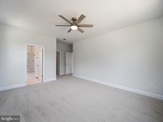 unfurnished bedroom featuring light colored carpet, connected bathroom, and baseboards