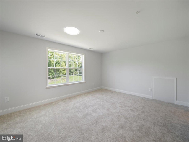 unfurnished room with carpet flooring, baseboards, and visible vents