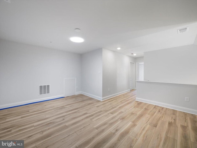 unfurnished room with baseboards, visible vents, and light wood-type flooring