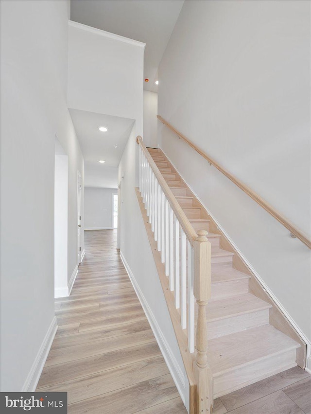 stairs with recessed lighting, wood finished floors, and baseboards