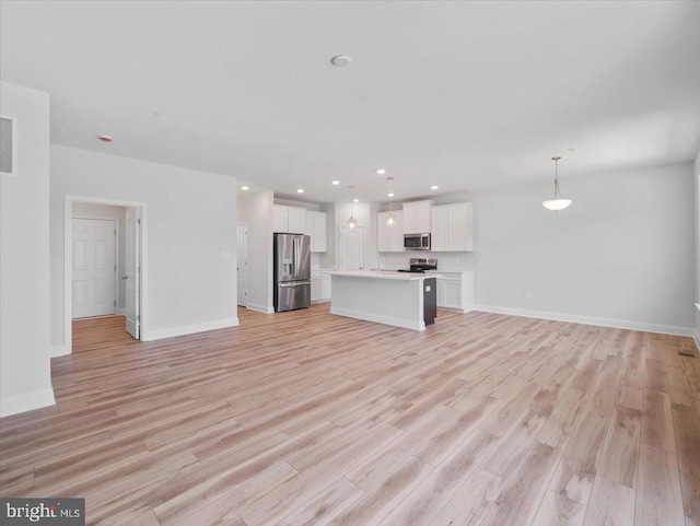 unfurnished living room with visible vents, recessed lighting, light wood-type flooring, and baseboards