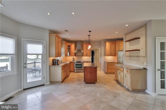 kitchen featuring a kitchen island, a sink, appliances with stainless steel finishes, wall chimney exhaust hood, and backsplash