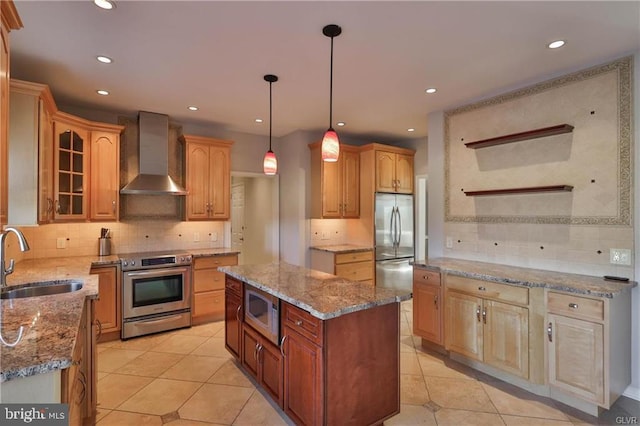 kitchen with a sink, appliances with stainless steel finishes, light tile patterned floors, and wall chimney range hood