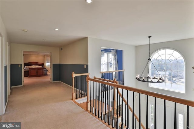 hall with recessed lighting, an upstairs landing, an inviting chandelier, and carpet flooring